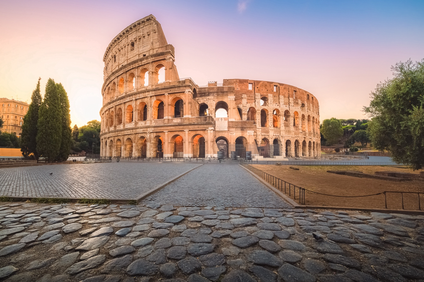 The ancient Colosseum in Rome, standing tall with its iconic arches, illuminated by daylight.