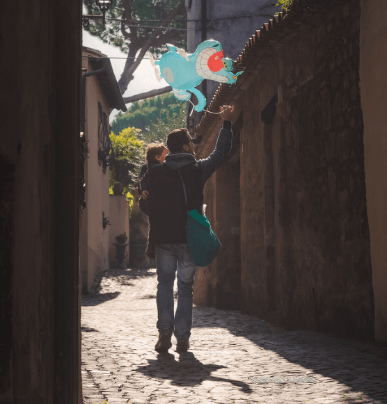 A father carrying his daughter and a balloon on the street of Orvieto.